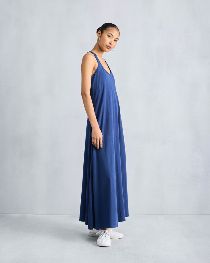 Person wearing a navy sleeveless Esther dress with a scoop neck.