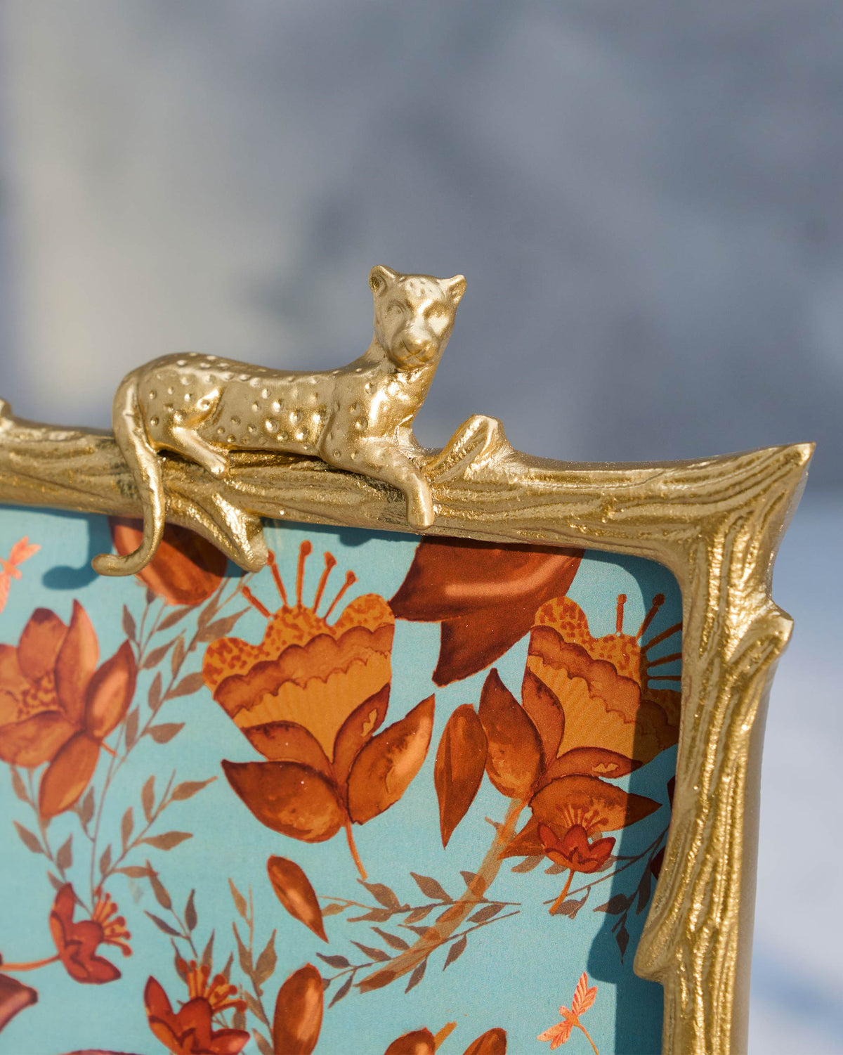 Close-up of the lounging gold leopard on a Jozani photo frame.