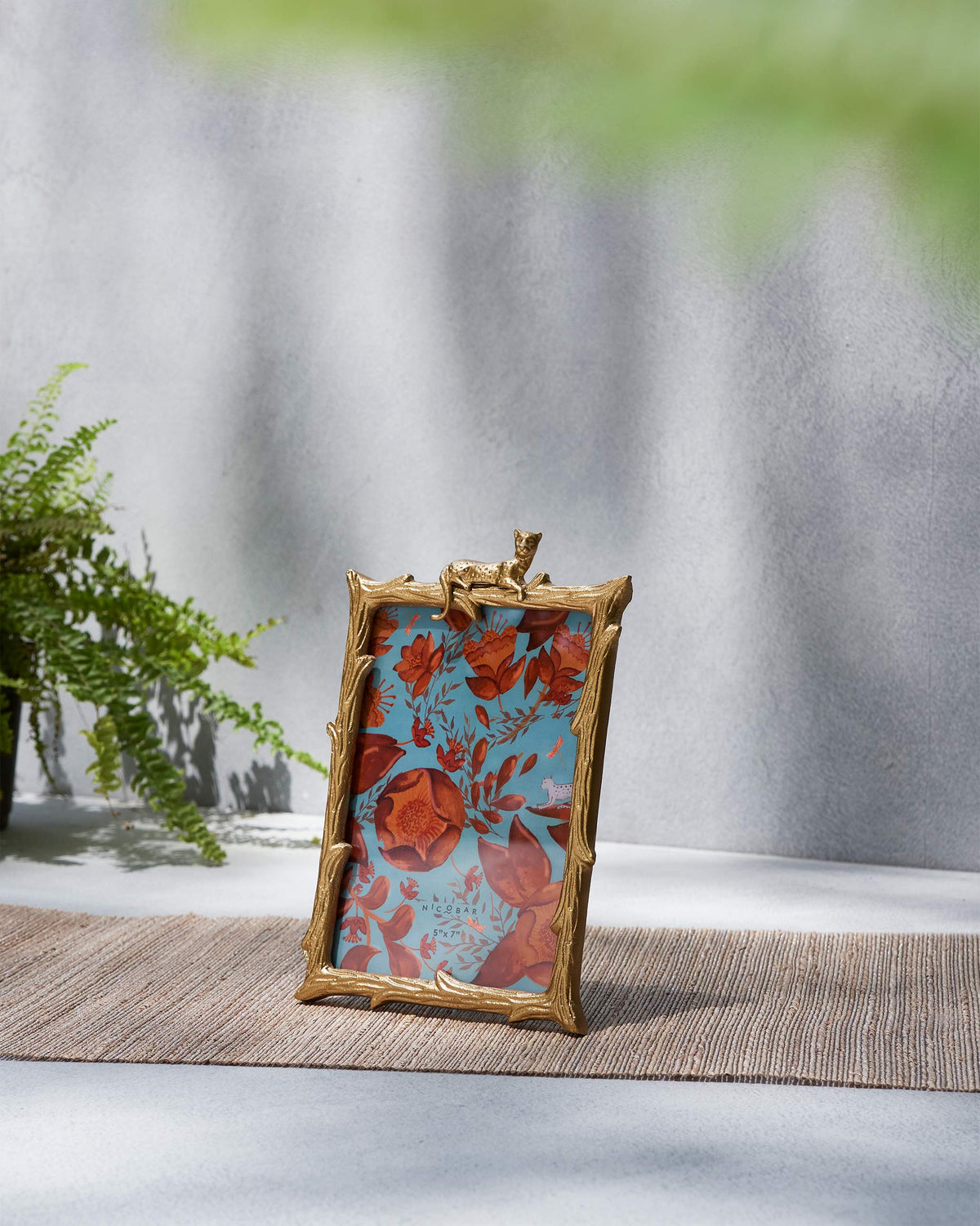 Jozani photo frame with gold branch border and lounging leopard.