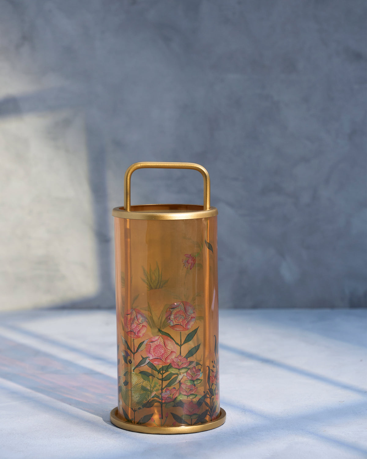 Side view of Flamingo Lantern in amber glass, showing its pink printed flowers.