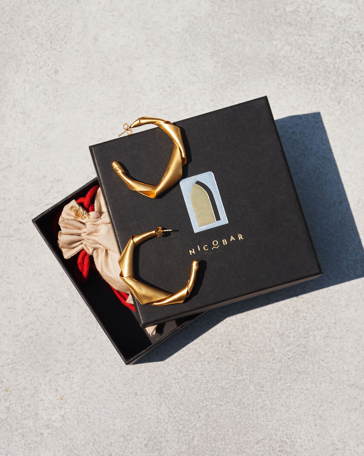 Ribbon Hoop Small gold earrings in a Nicobar gift box.