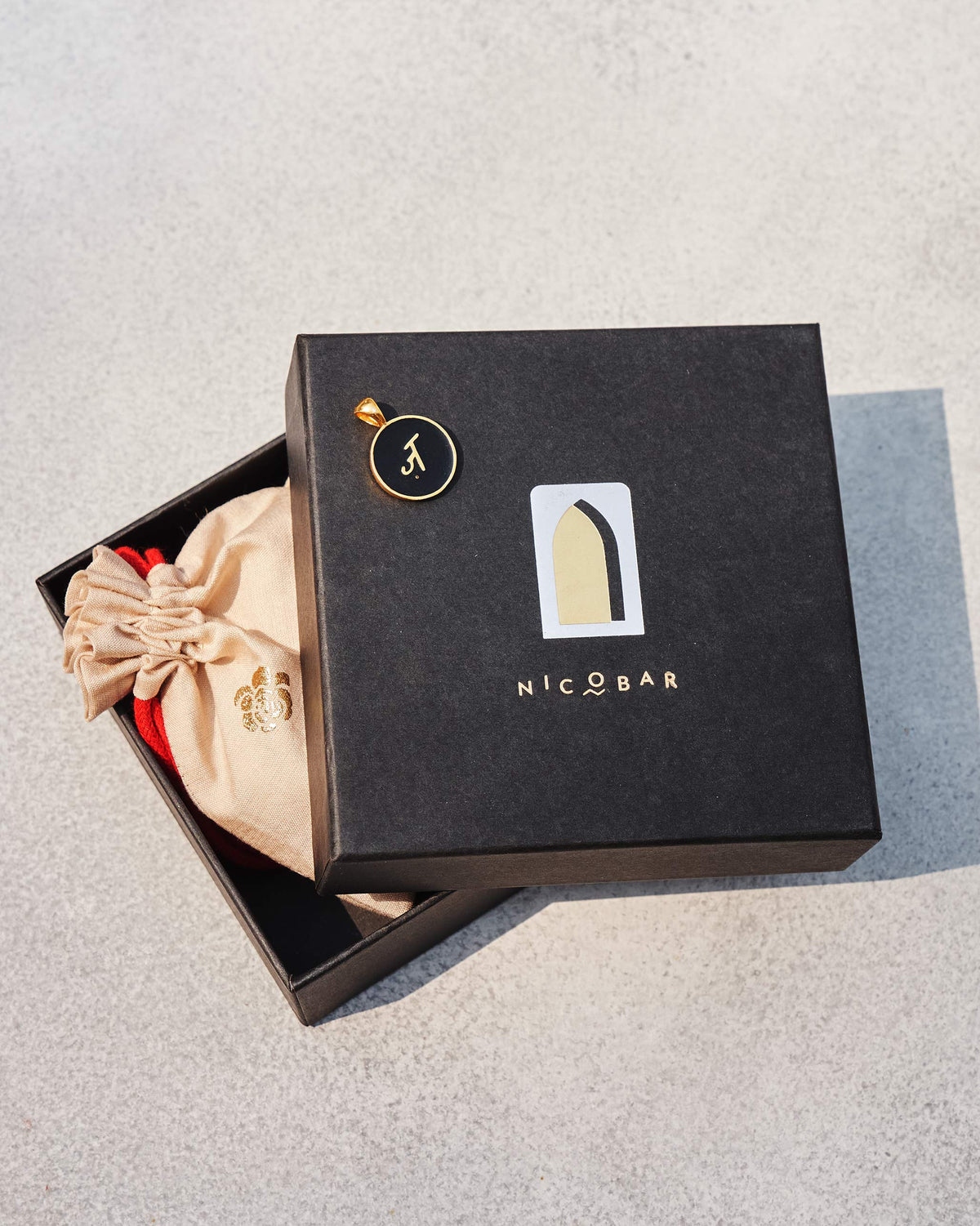 Black and gold Alphabet Z charm on a Nicobar gift box.