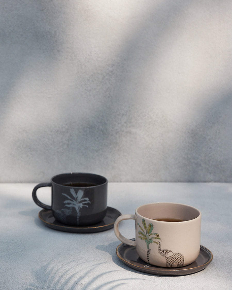 The Coastal Mugs on dark saucers.