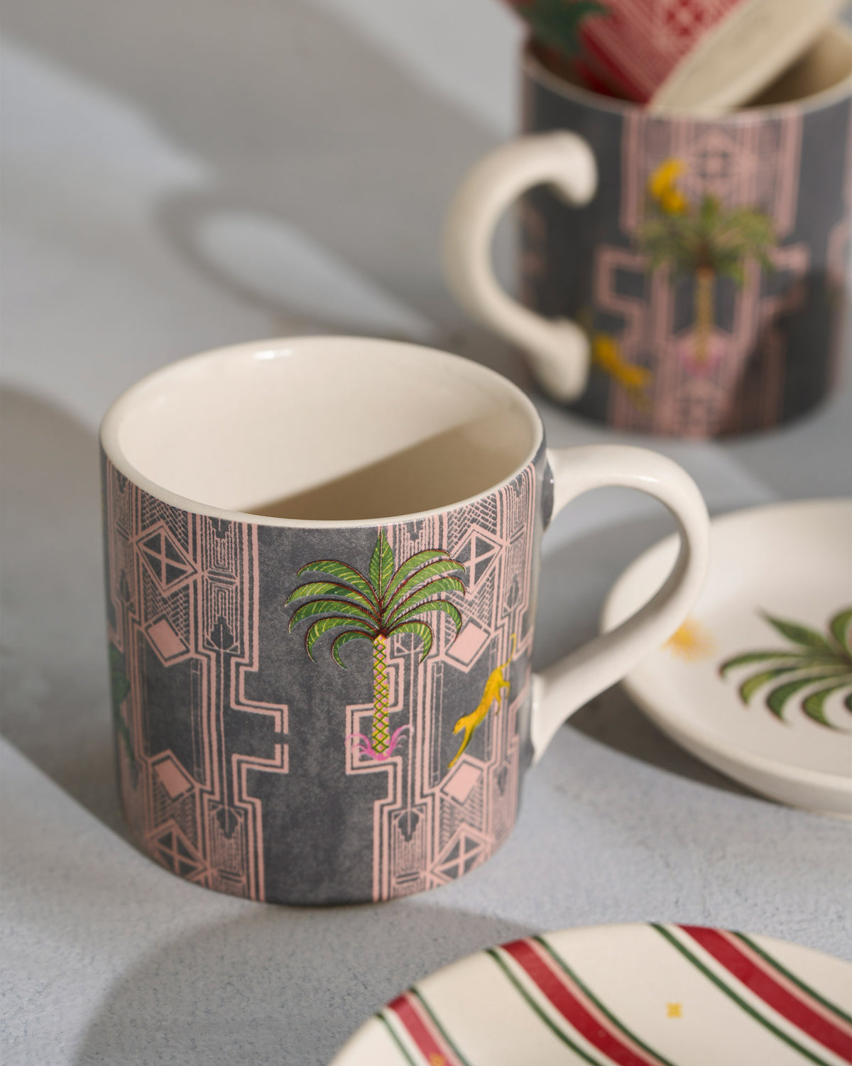 Close-up of a Leafy Affair mug with palm tree and geometric print.