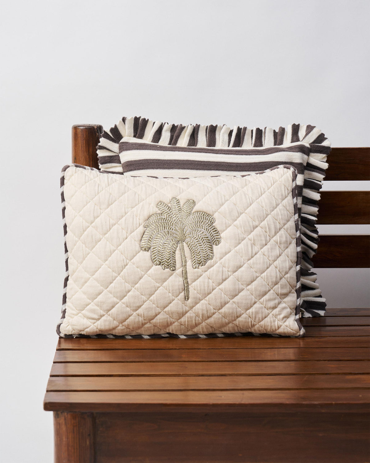 Ivory Quilted Palm cushion cover with embroidered palm and striped piping.