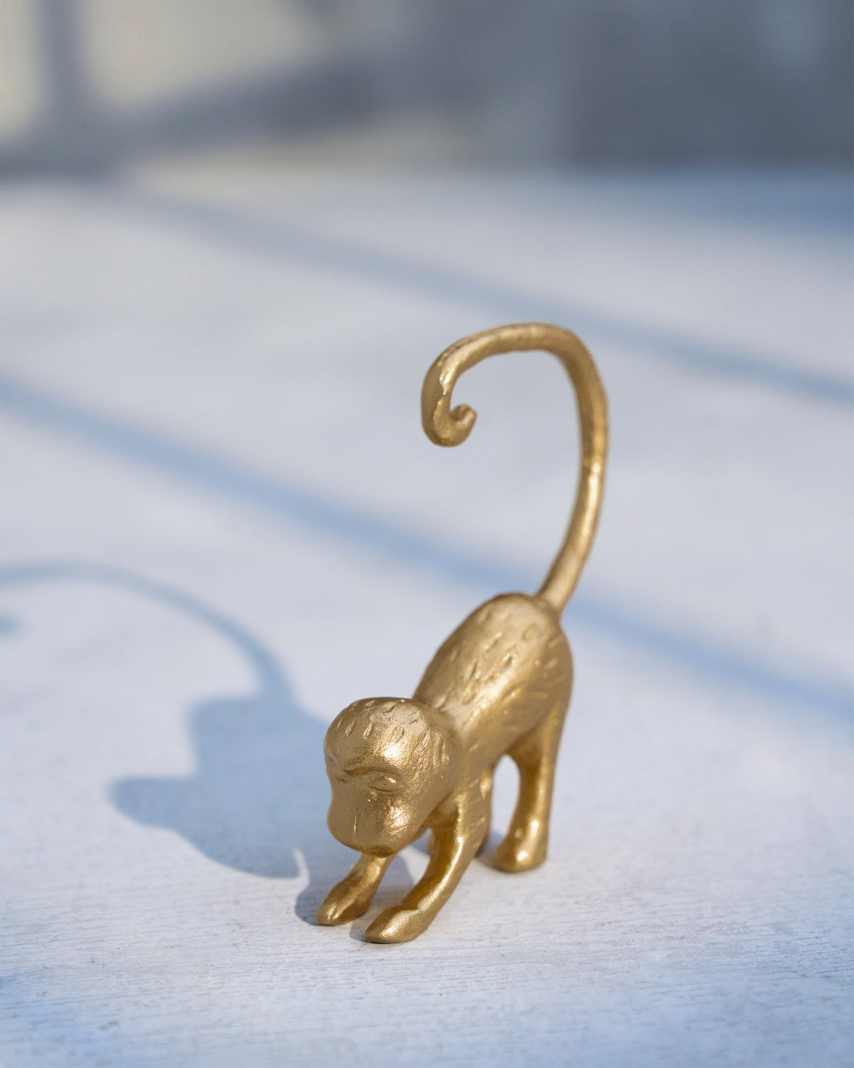 Gold monkey menu card holder from the Jungle Table Set with a curled tail.