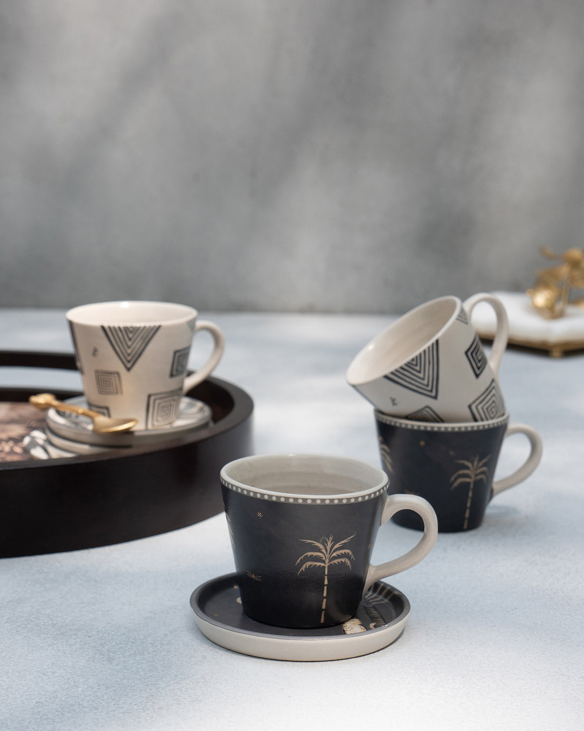 Serenity espresso mug with a gold palm print on a matching saucer.