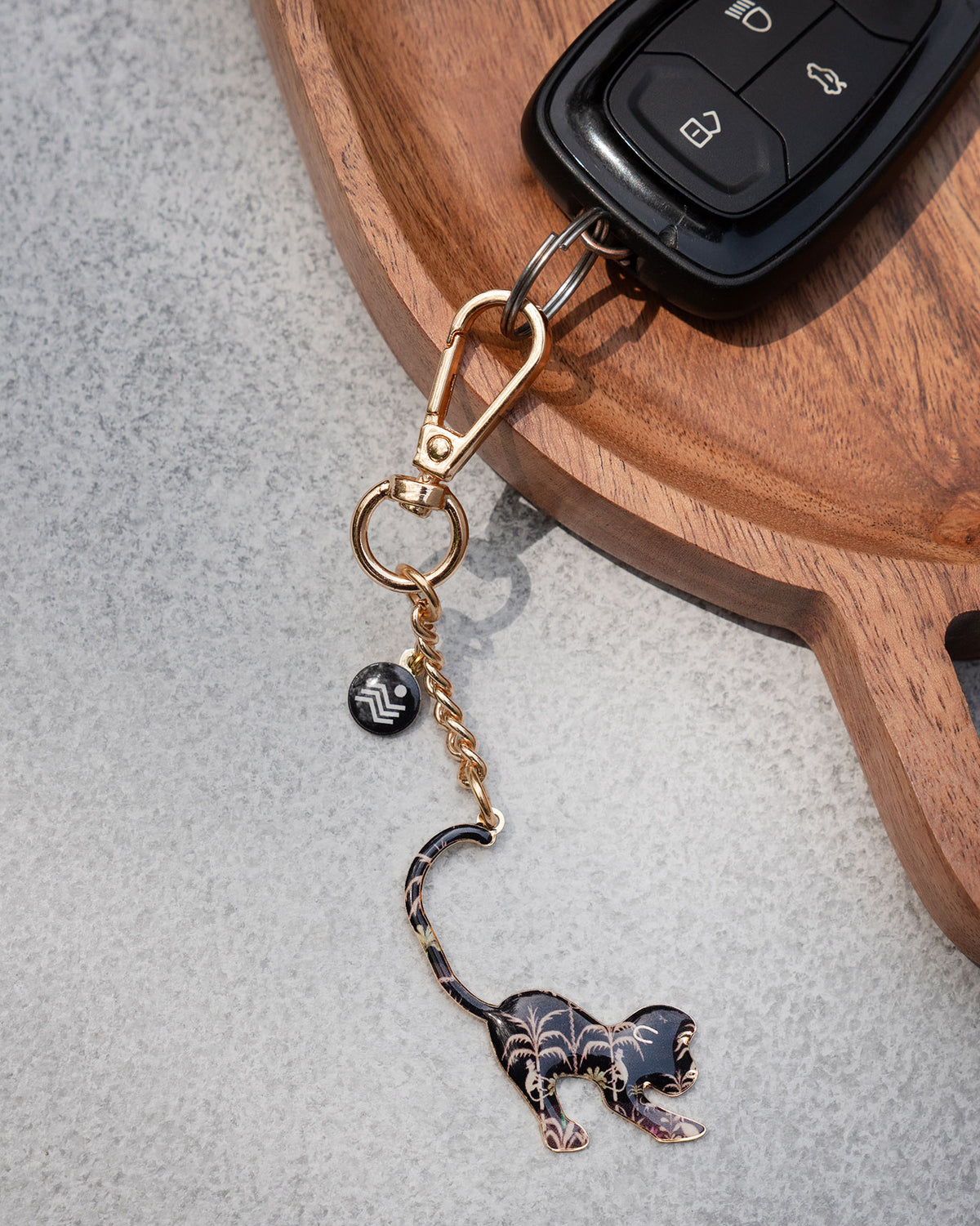 Monkey keychain with palm motifs clipped to a car key fob.