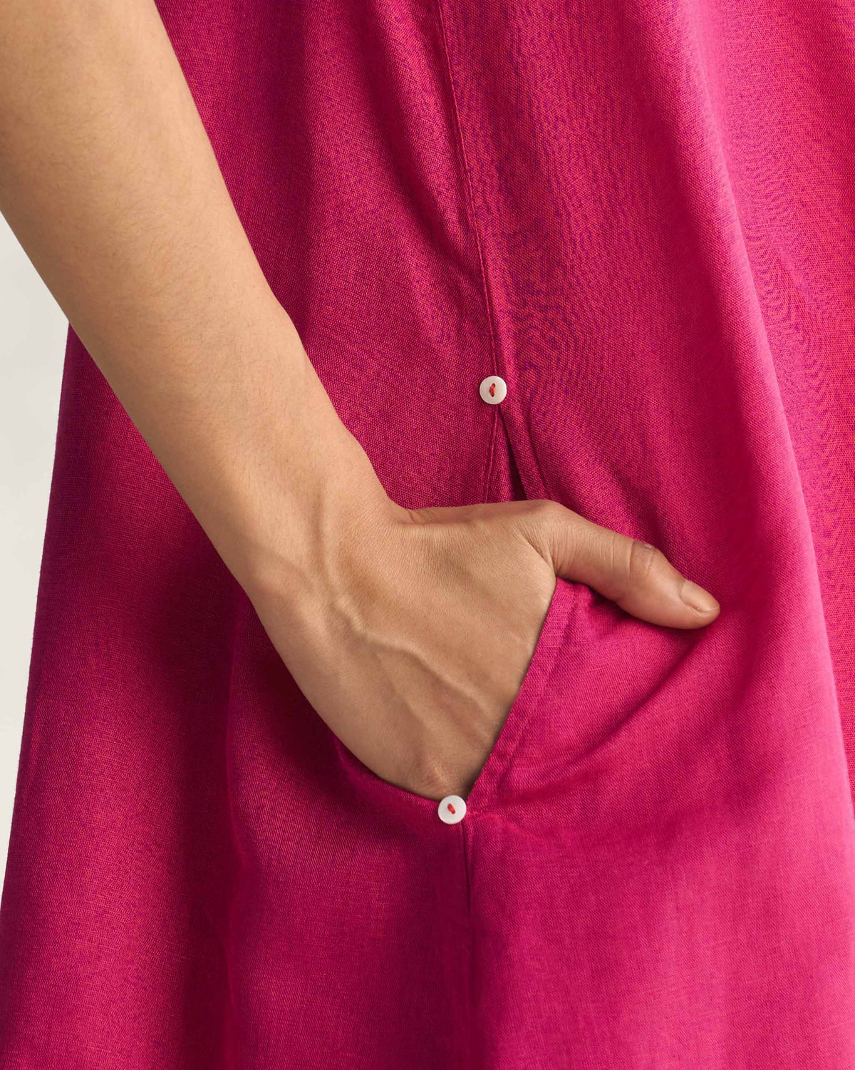 Close-up of a pink Double layer dress pocket with small buttons.