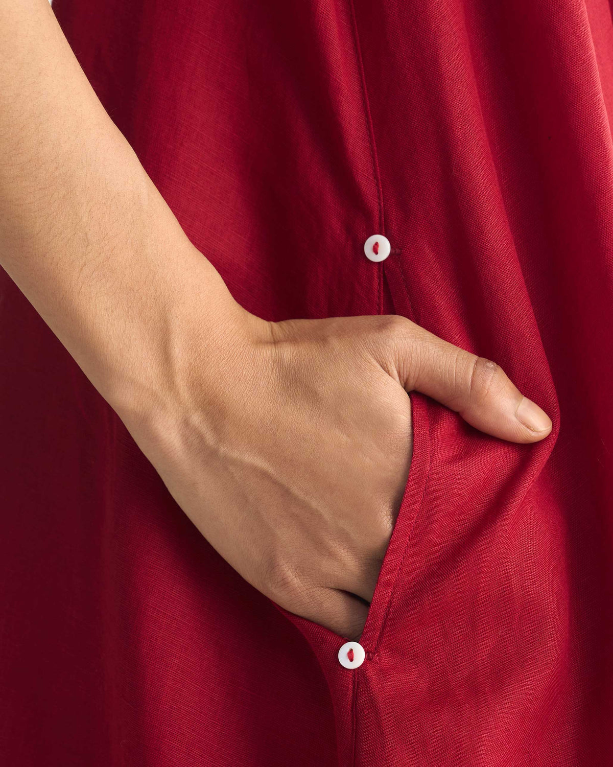 Close-up of a red Double layer dress pocket with small buttons.