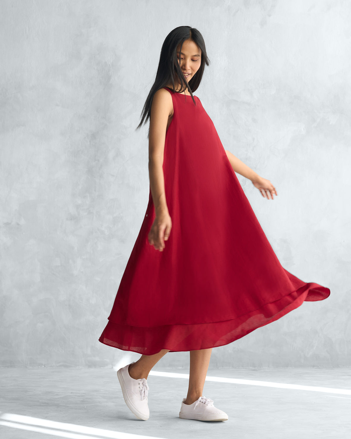 Side view of a red Double layer dress with a flared, layered hem.