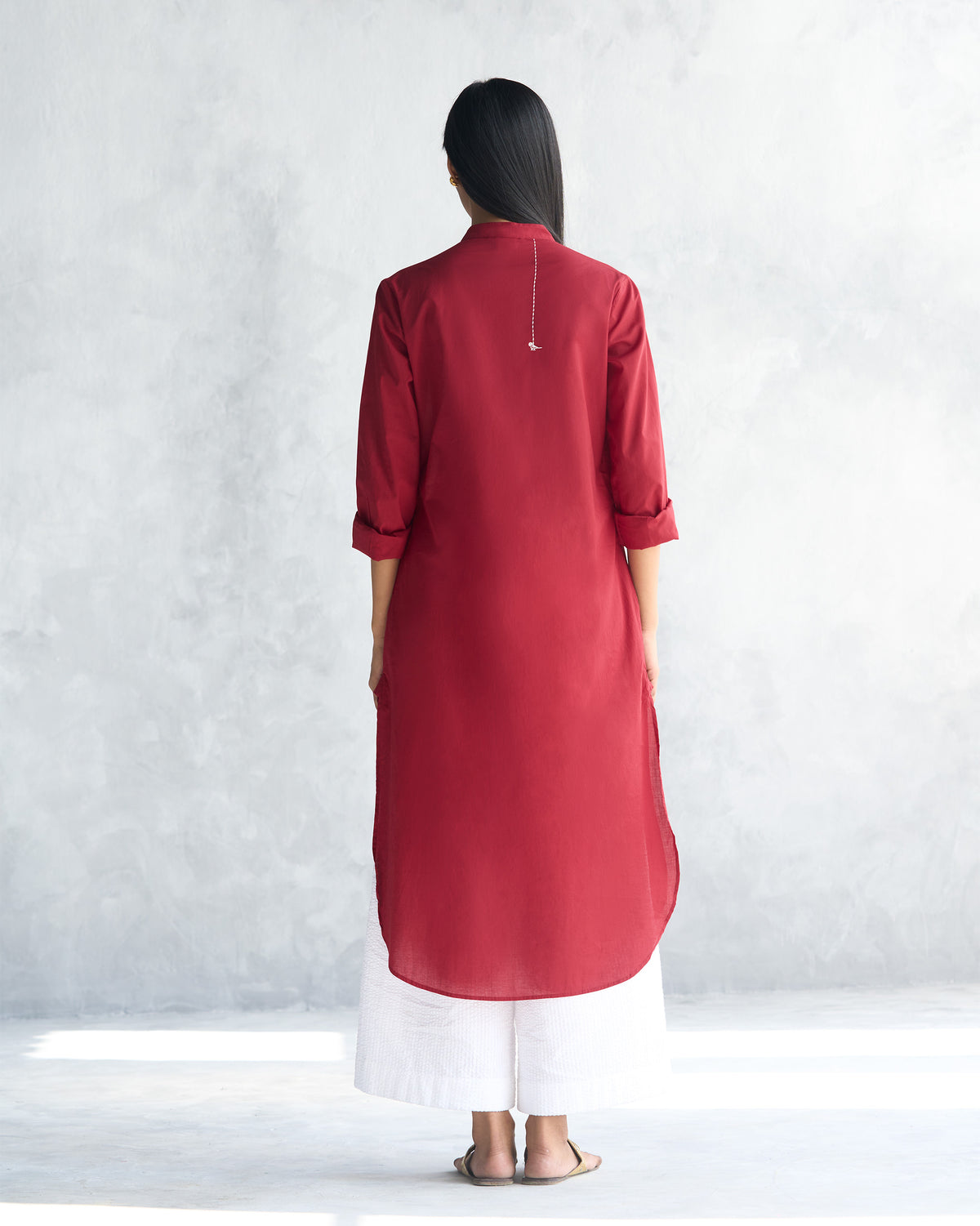 Back of a red long kurta showing the curved mid-calf hem.