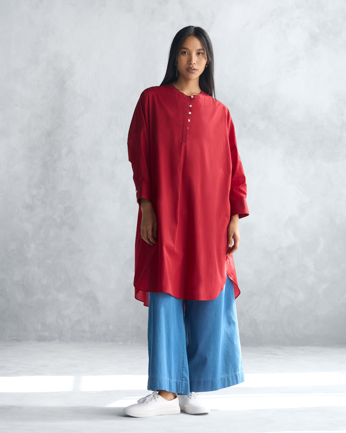 Person wearing a red Lazy Sunday tunic with a relaxed mid-thigh length.