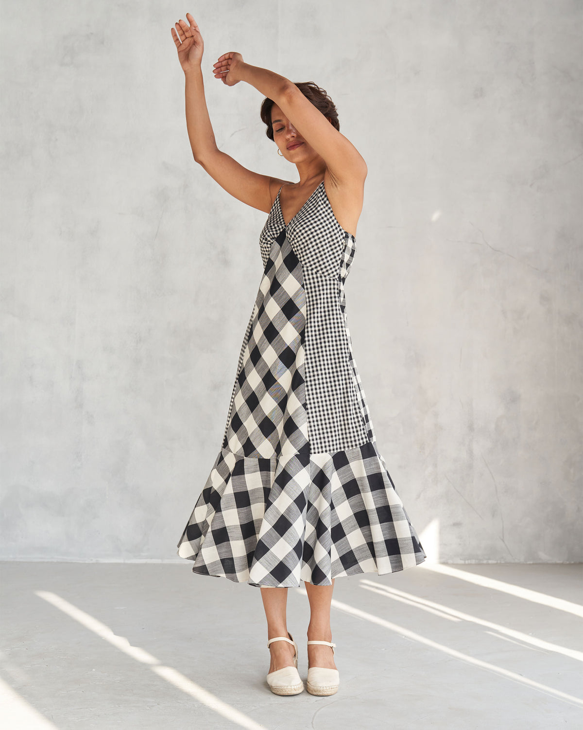 Ivory and black mixed-check strappy dress with a flared tiered hem.