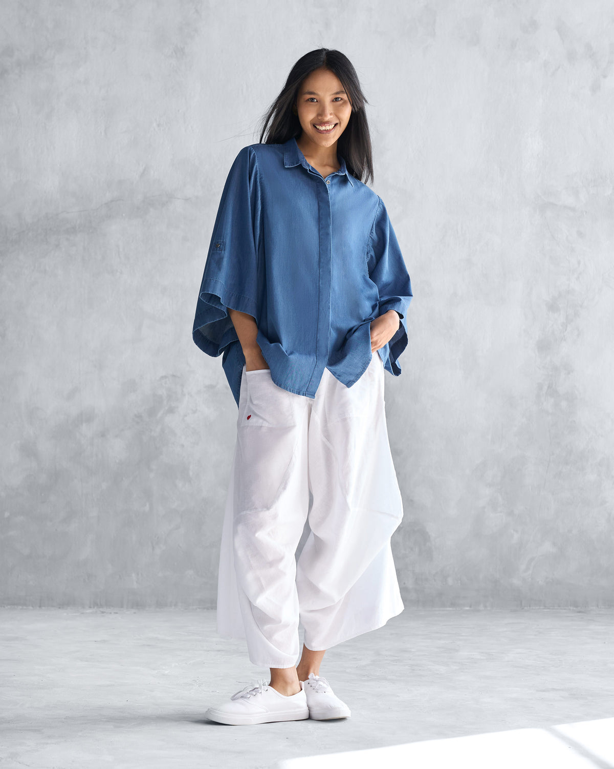 Full-length view of the blue Drop Armhole Shirt worn by a person.