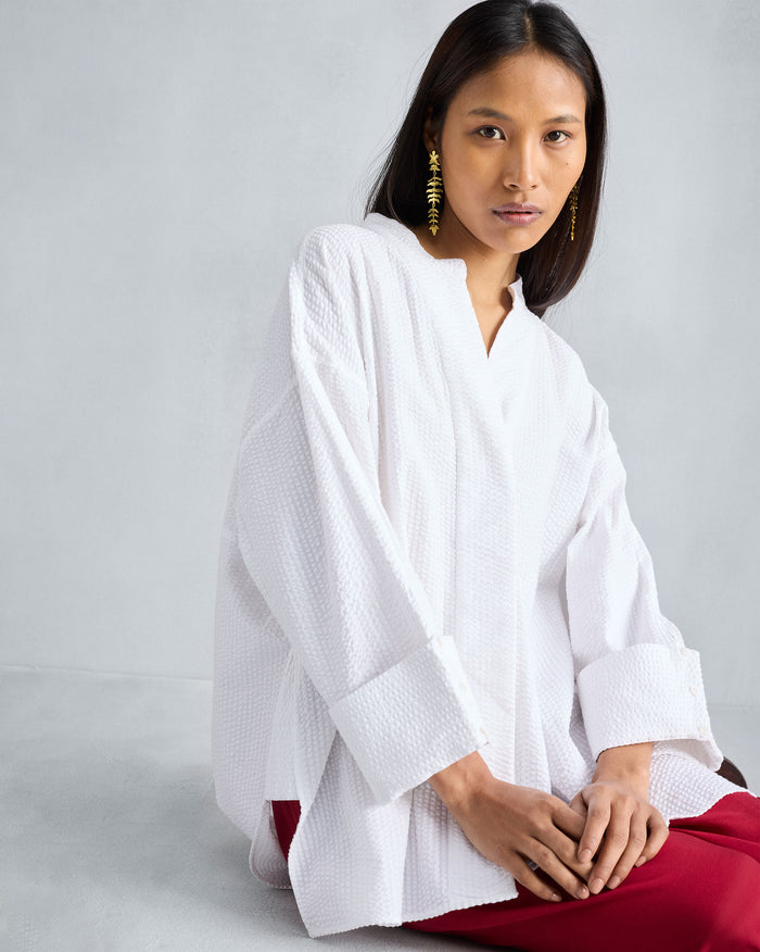 Person wearing a white Cirrus seersucker shirt with wide cuffs.