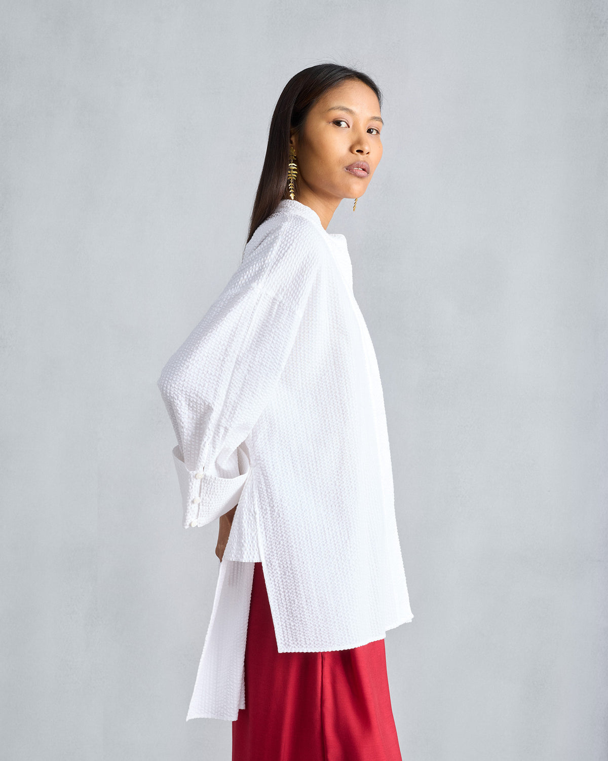 Side view of a white Cirrus seersucker shirt with a deep side slit.