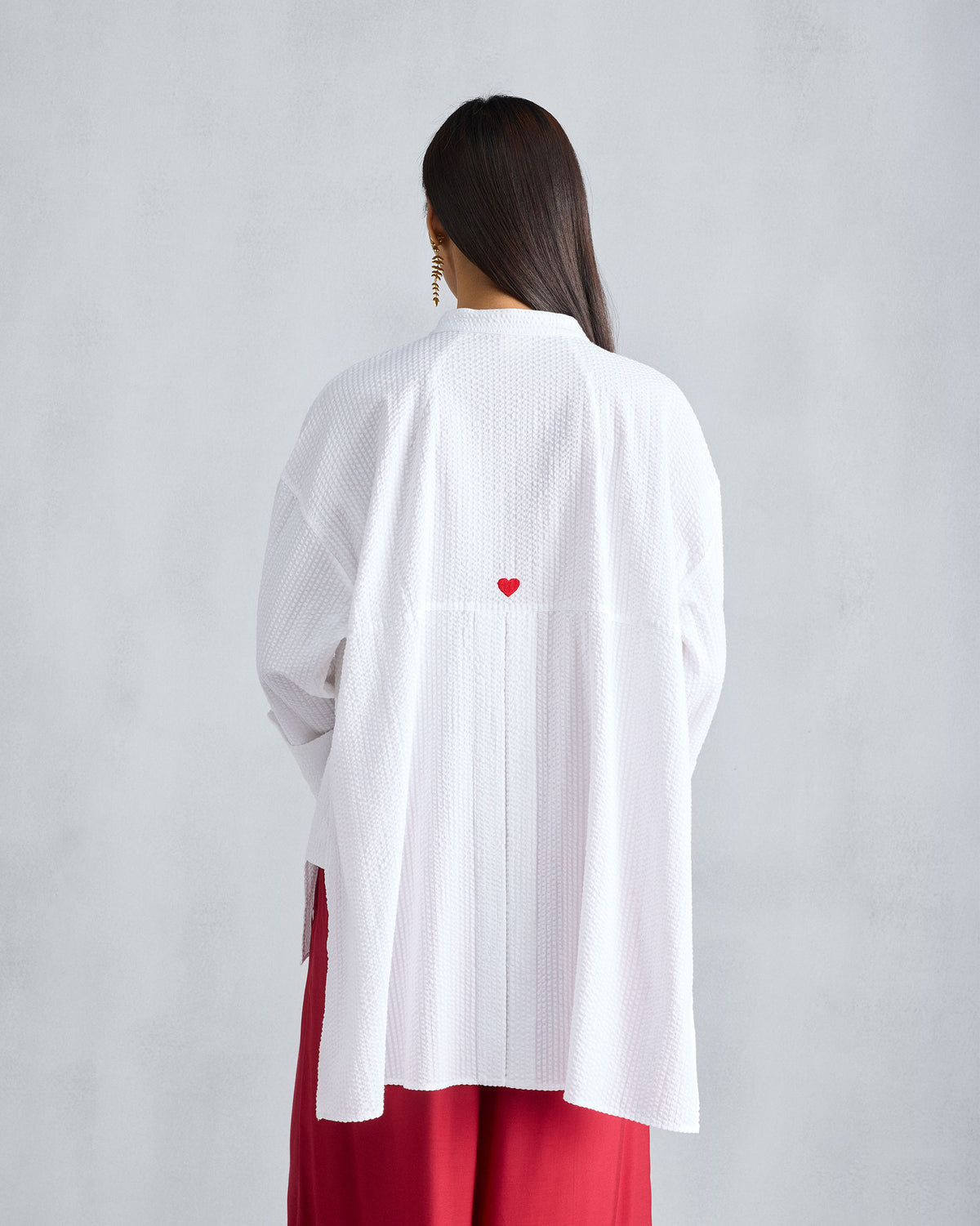 Back of a white Cirrus seersucker shirt with a red embroidered heart.