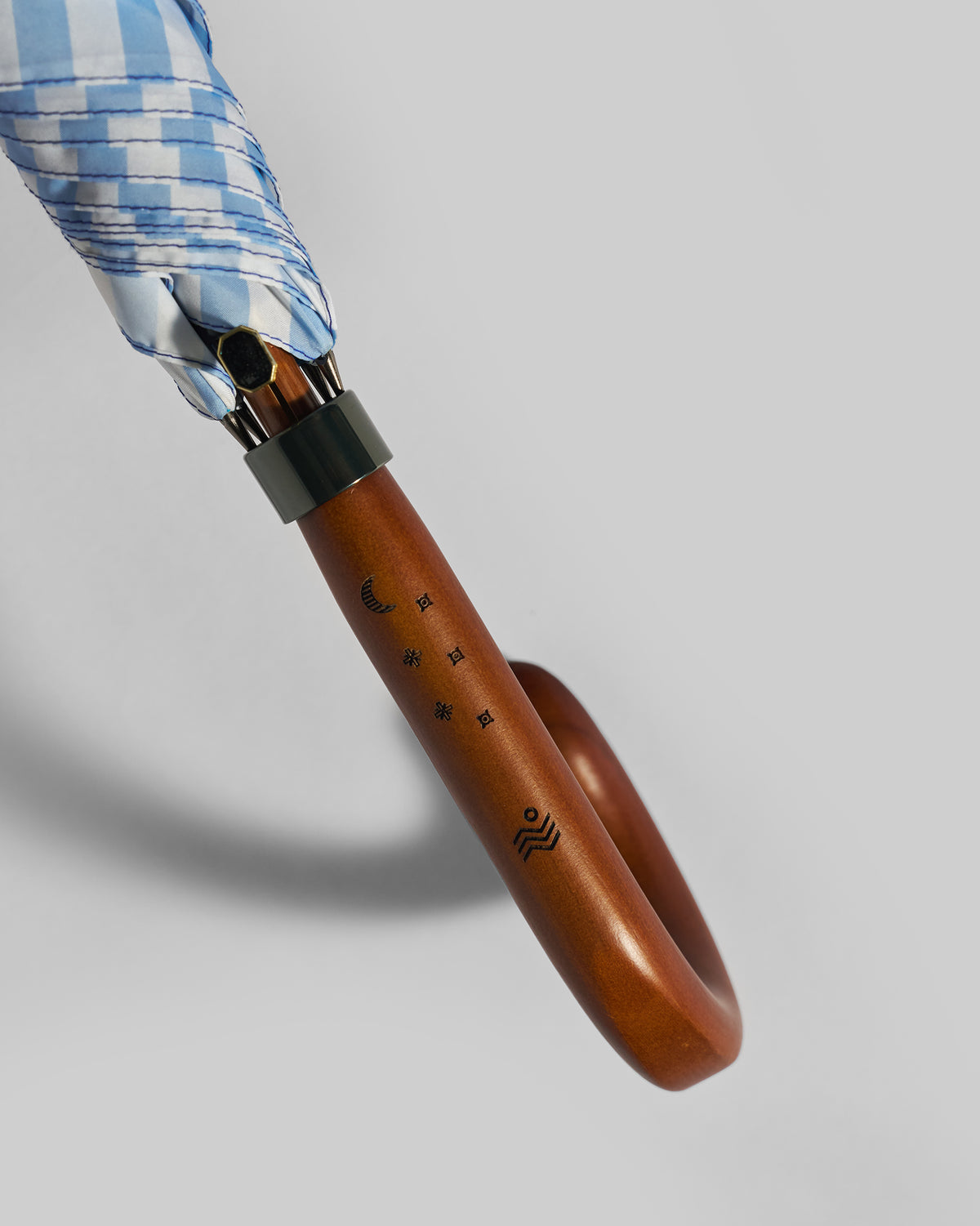 Close-up of the Zanzibar Umbrella curved handle with etched moon and star marks.