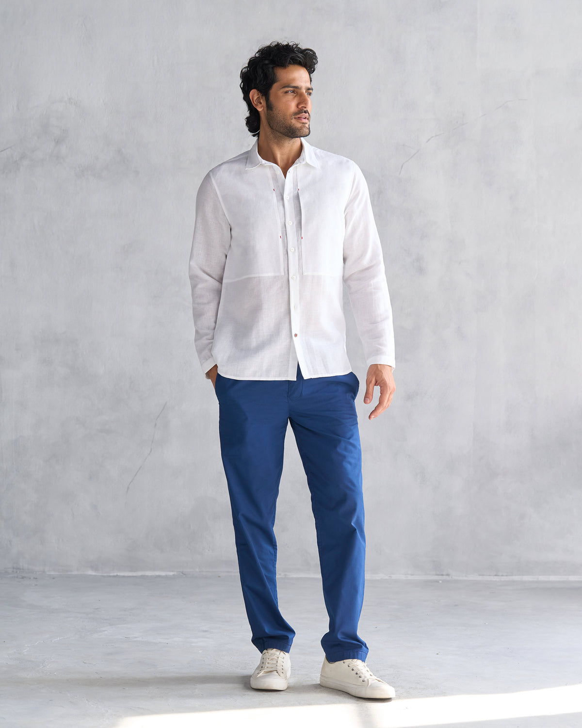 Full-length view of a white August Shirt worn by a person.