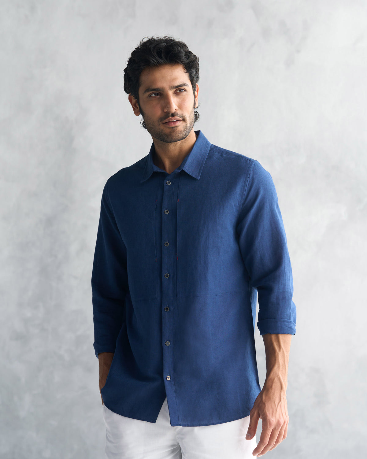 Person wearing a navy August Shirt with rolled sleeves.