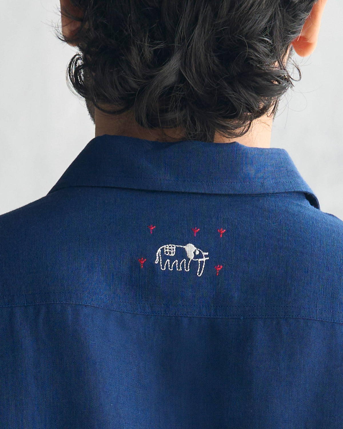 Close-up of elephant embroidery on the back of a navy August Shirt.