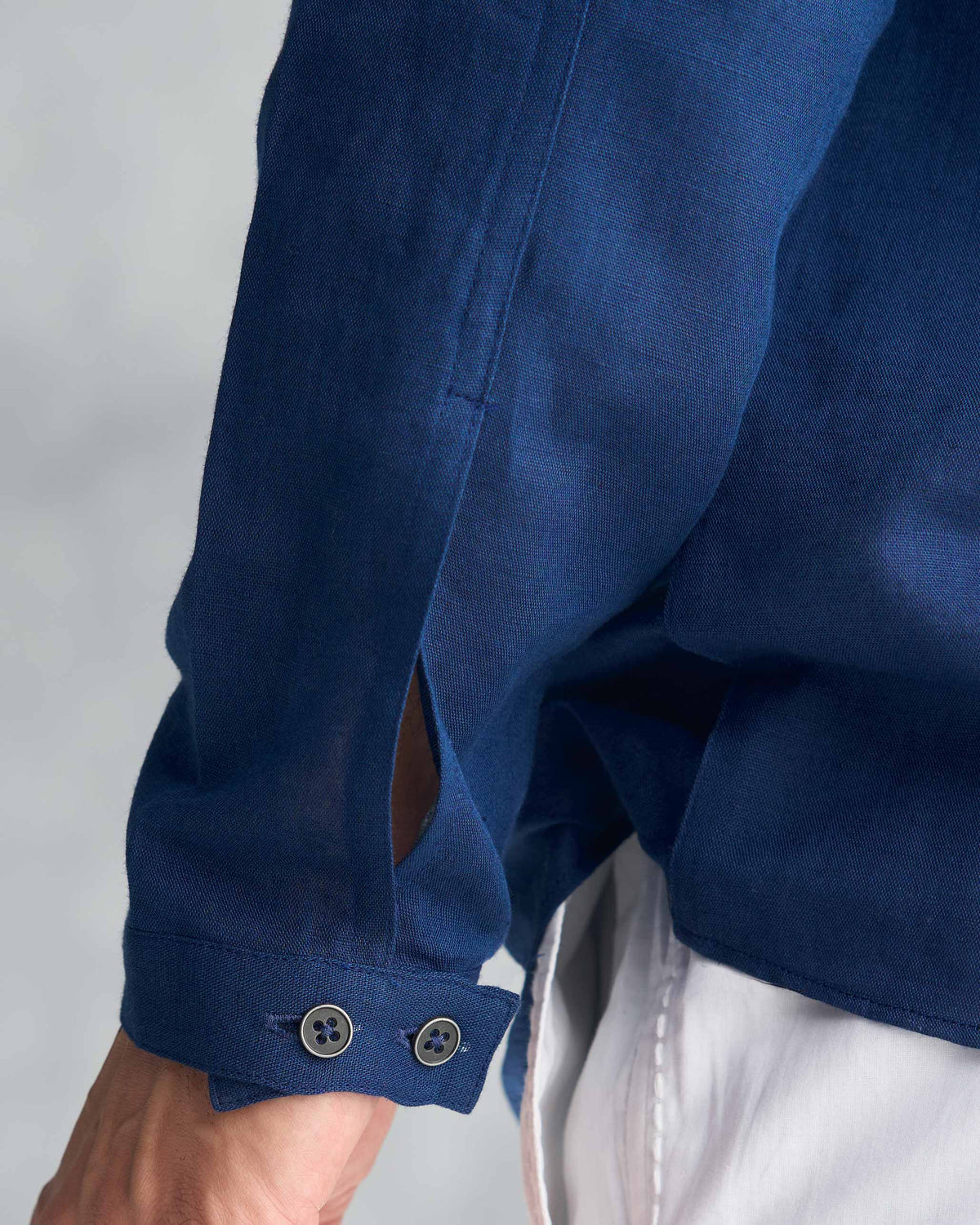 Close-up of the buttoned cuff on a navy August Shirt.