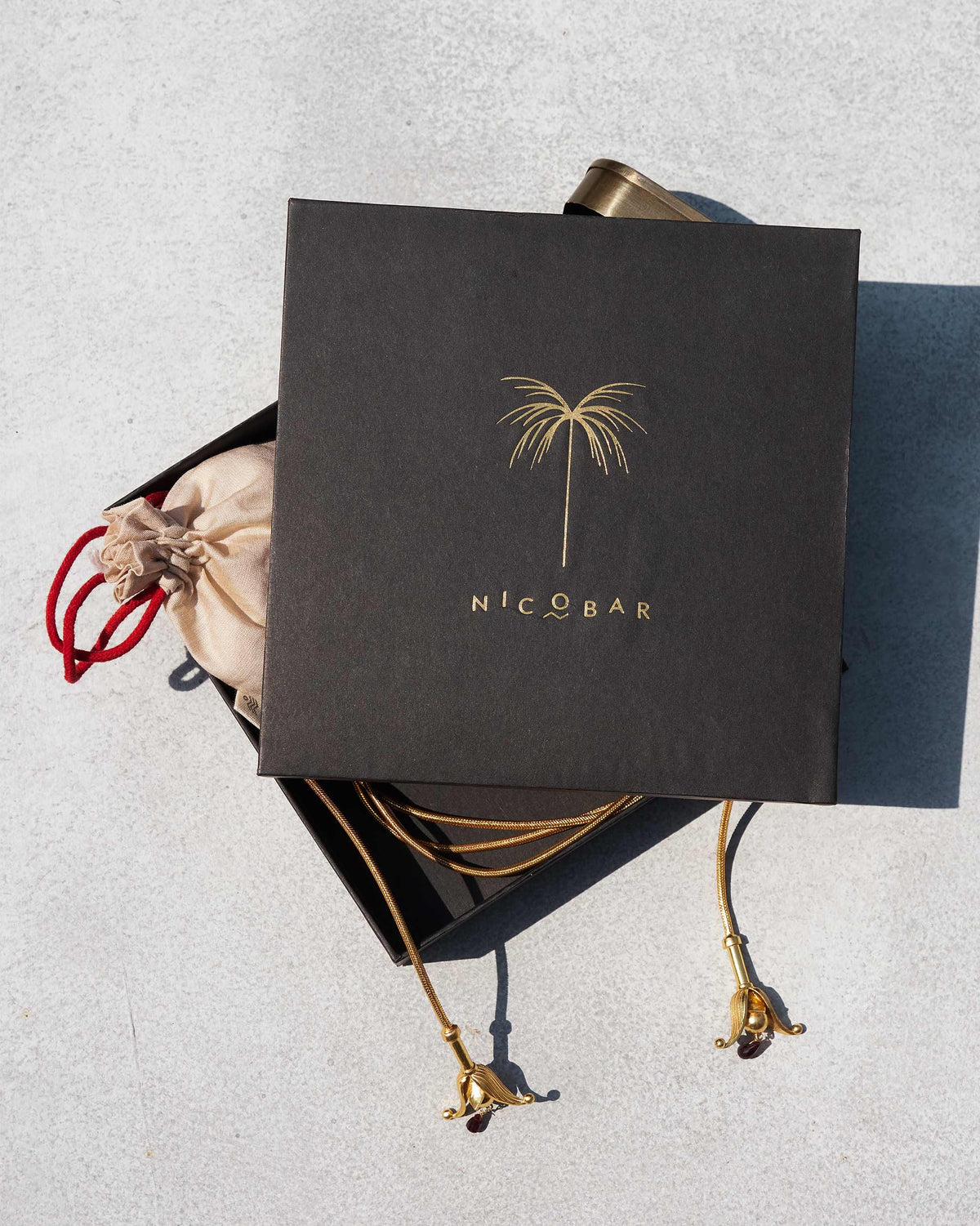 Gold Phool Chain beside a black gift box and cream pouch.