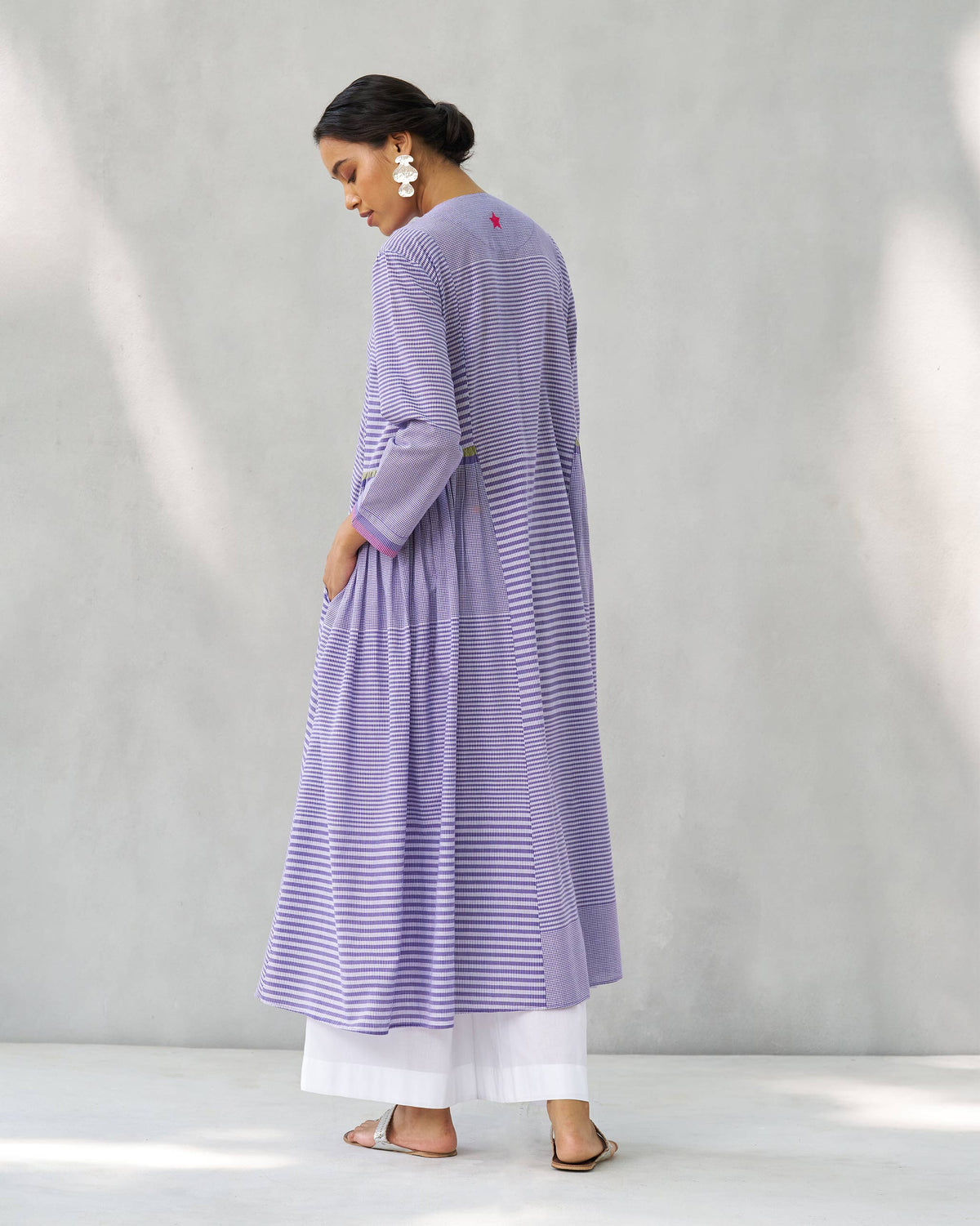 Back of a purple and white Pintuck kurta showing the flared length and neck star.