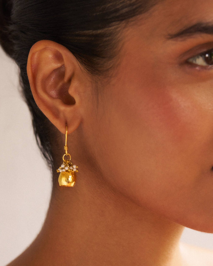 Person wearing gold Pearl Poppy Drop Earrings with a pearl cluster.
