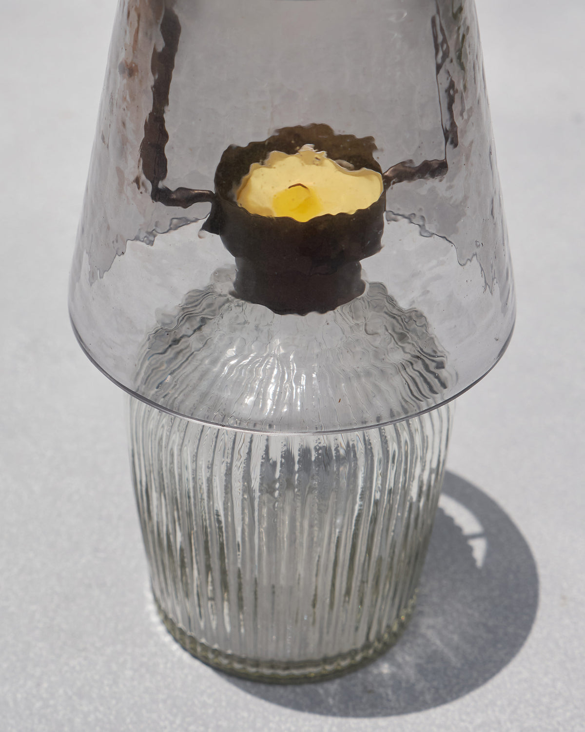 Asfar votive with a ribbed clear base and hammered smoky glass shade.