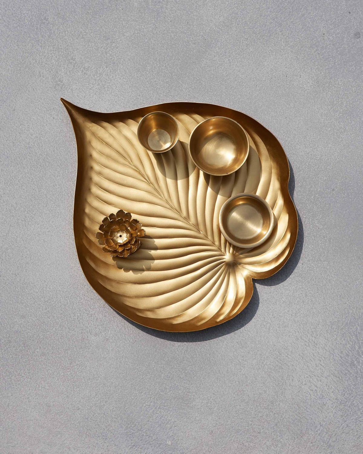 Asfar pooja set brass leaf tray with bowls and lotus incense holder.