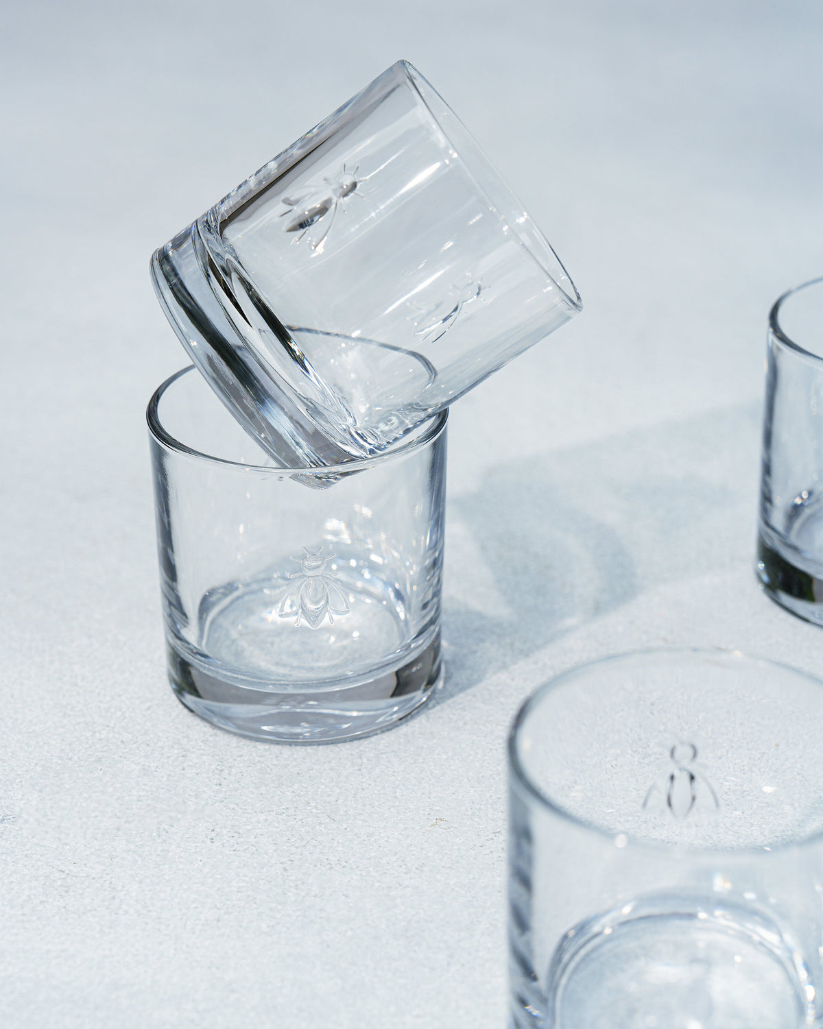 Stacked Bumble Bee whiskey glasses showing an embossed bee motif.