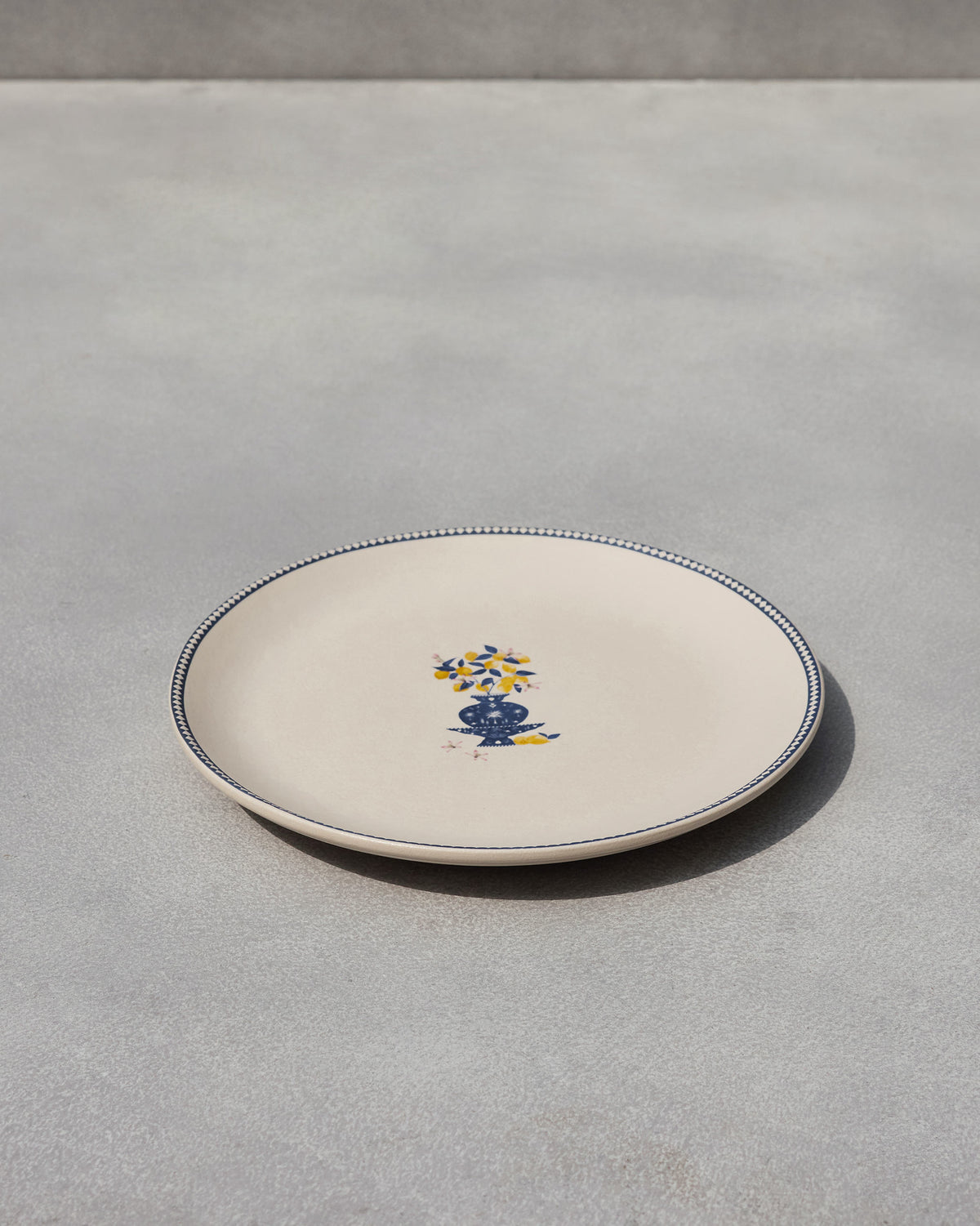 Sahara Dinner Plate at an angle, showing its blue vase motif.