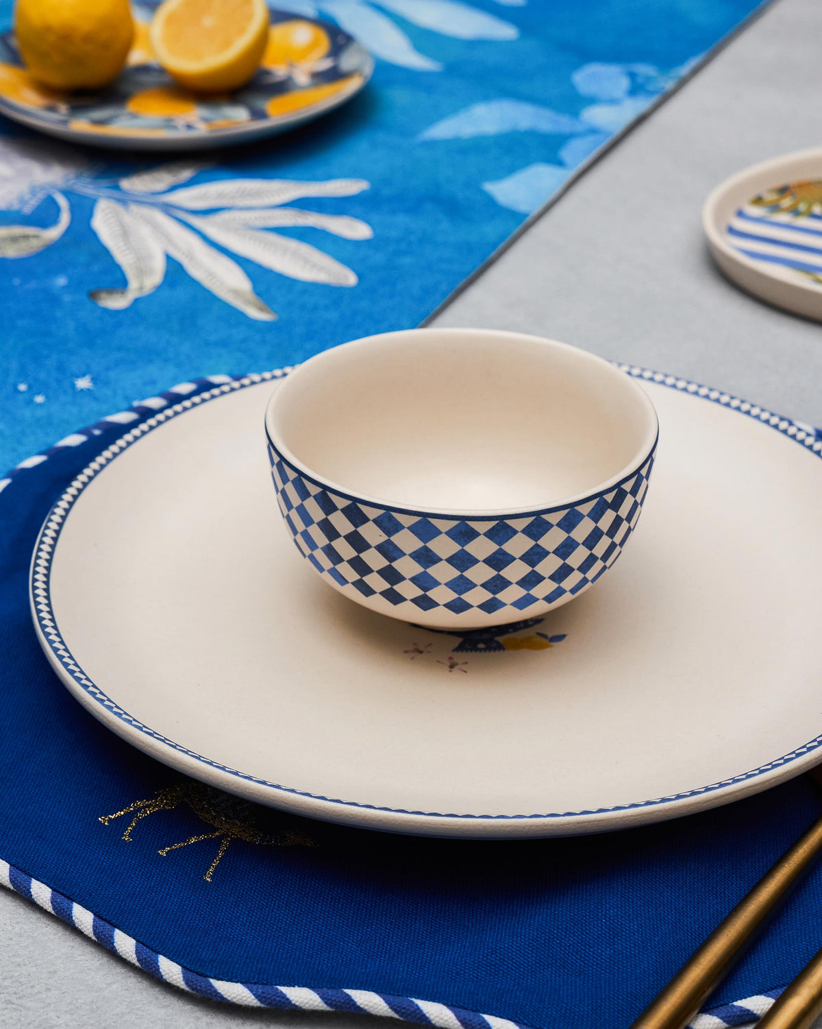 Sahara checkered katori on a cream dinner plate with a navy placemat.