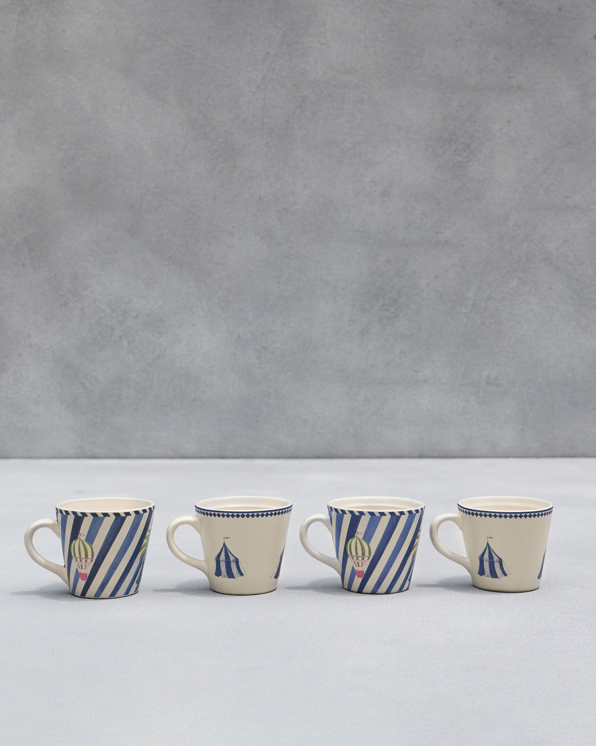 Row of four Sahara espresso mugs with circus tent and balloon prints.
