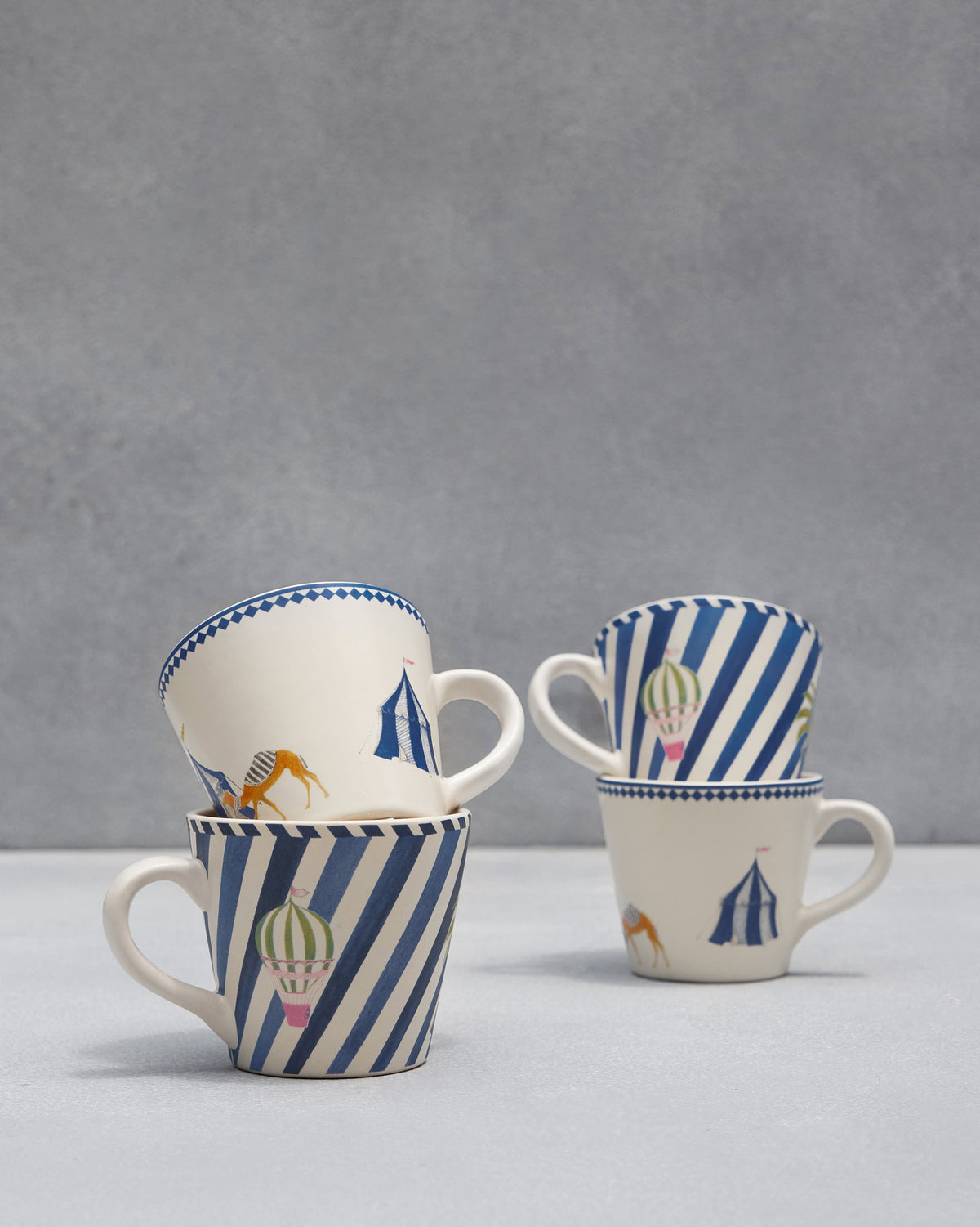 Stacked Sahara espresso mugs with camel, tent, and balloon prints.