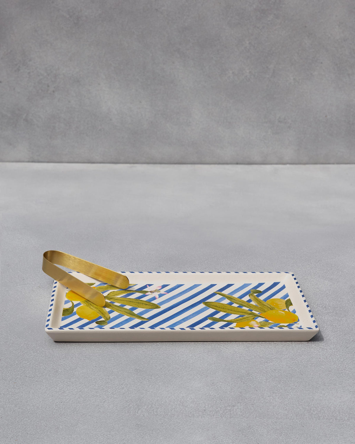 Asfar cookie tray with blue stripes, lemon motifs and a pair of gold tongs.