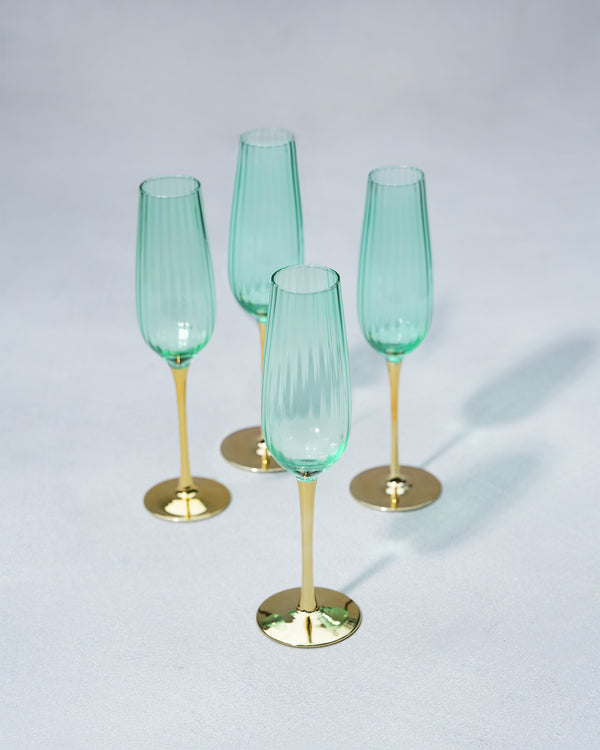 Four emerald flutes grouped together on a grey surface