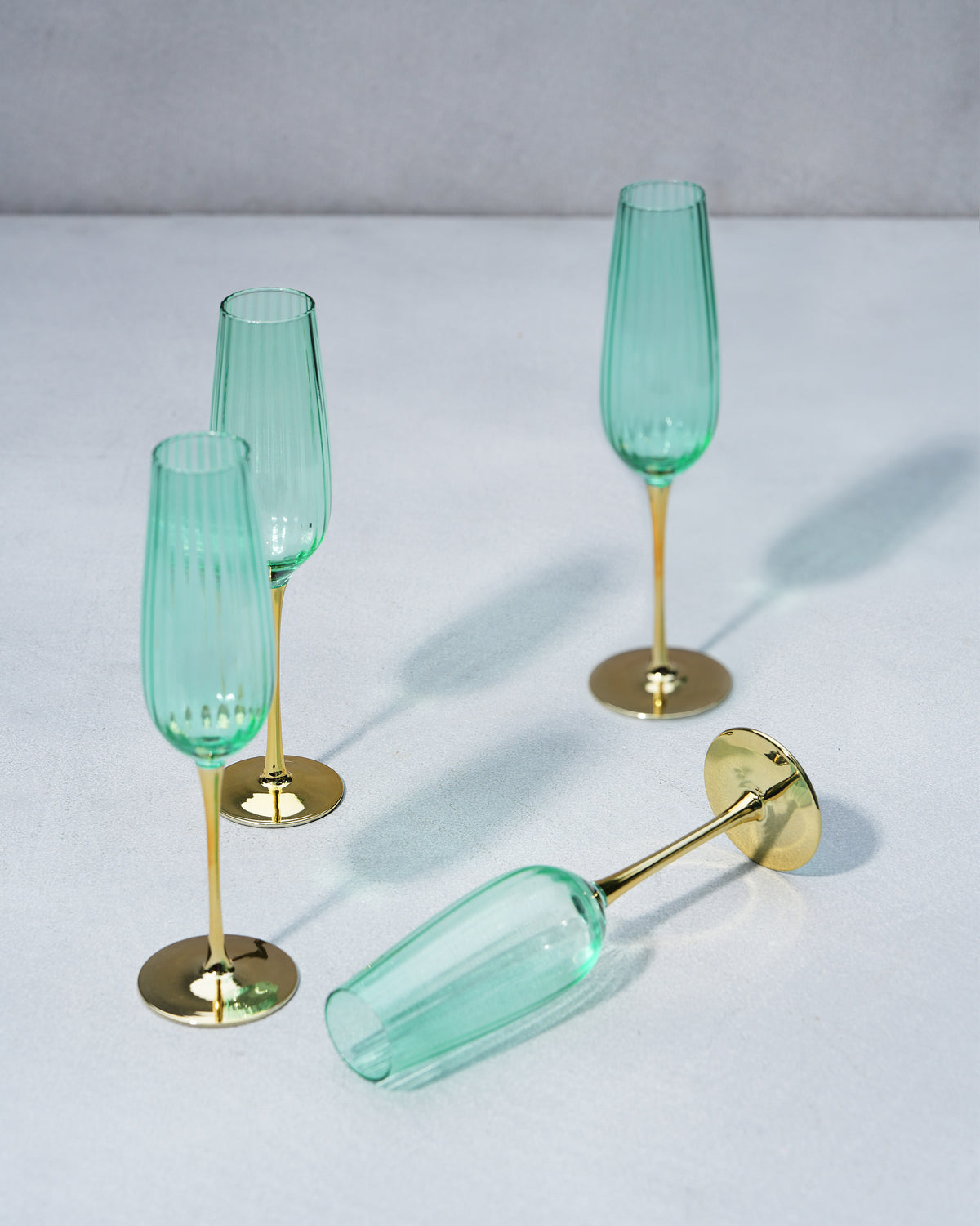 Seafoam green champagne flutes, one lying on its side.