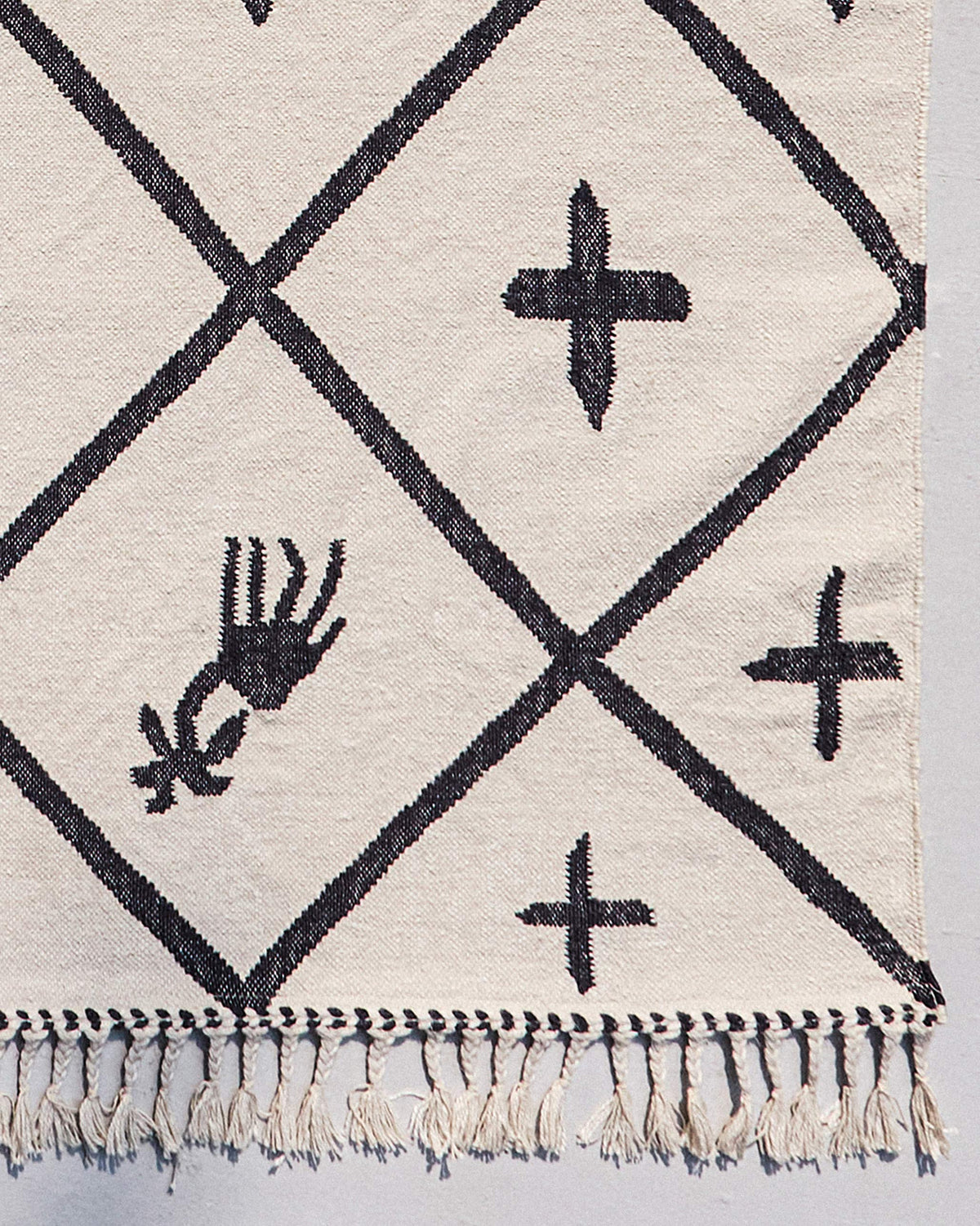 Close-up of a Morocco tiles rug corner with a fringed edge.