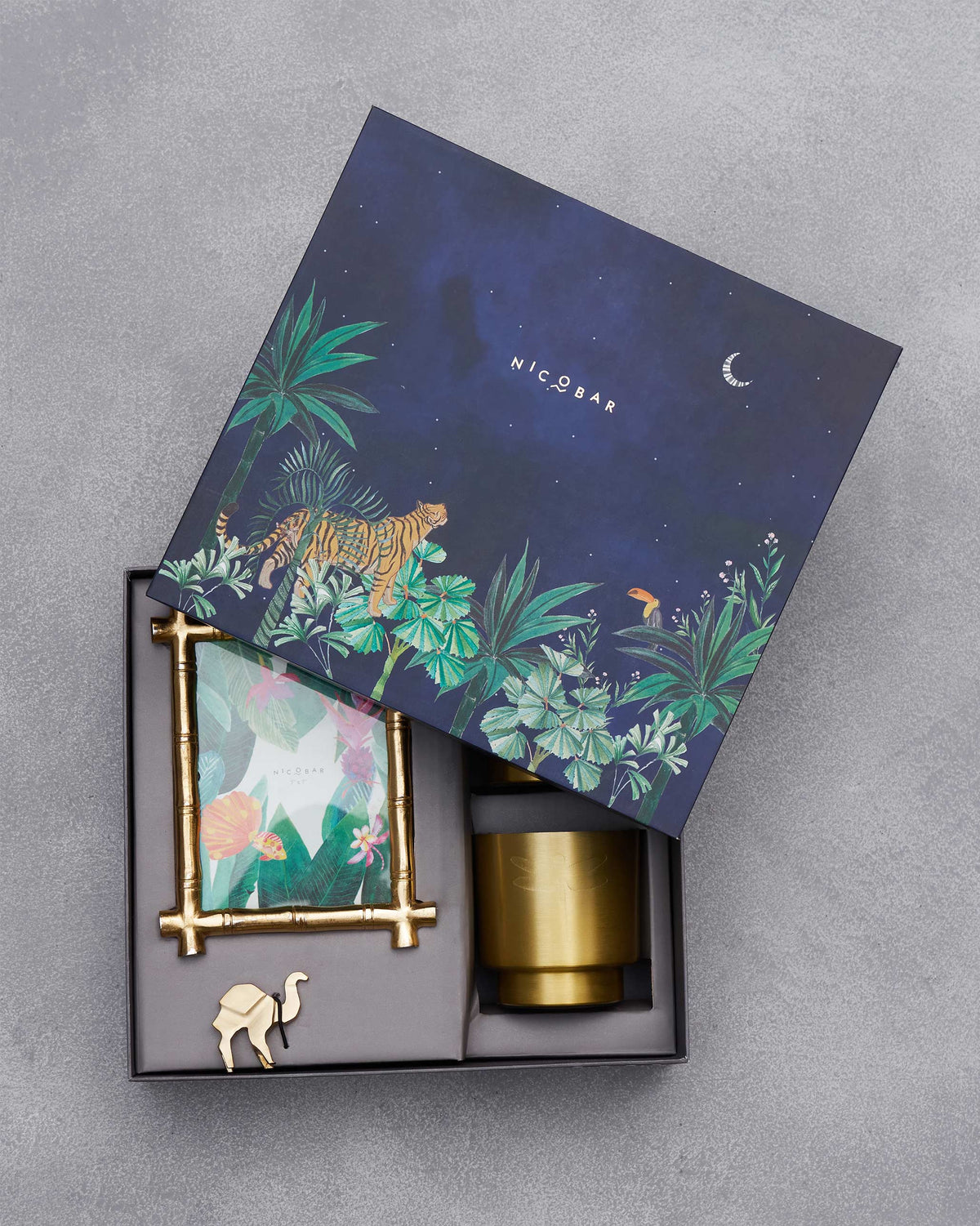 Jungle-illustrated lid over an open gilded desk set of brass accessories.
