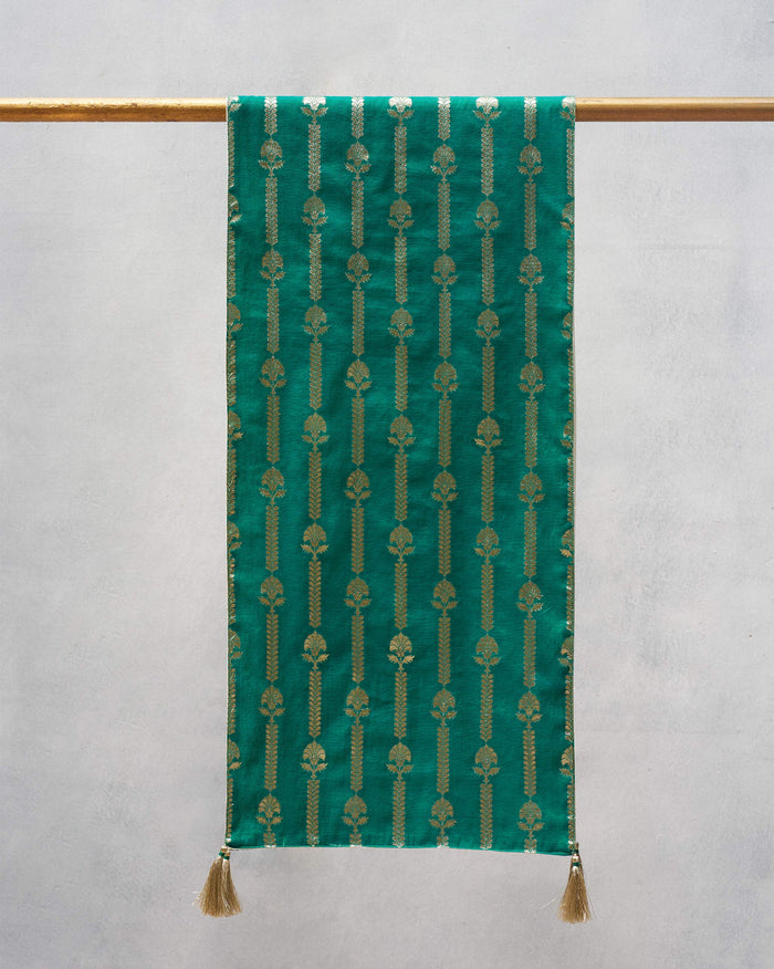 Dune Stripes Table Runner in green with gold vertical motifs and tassels.