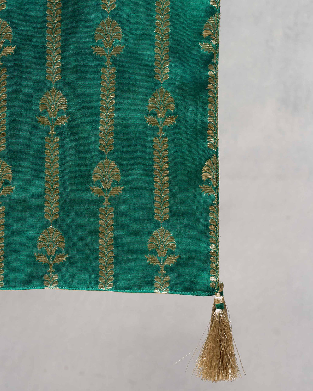 Close-up of Dune Stripes Table Runner showing gold motifs and a gold tassel.