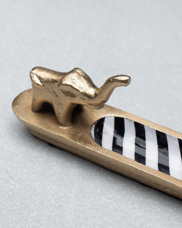 Close view of the gold elephant on the striped tray