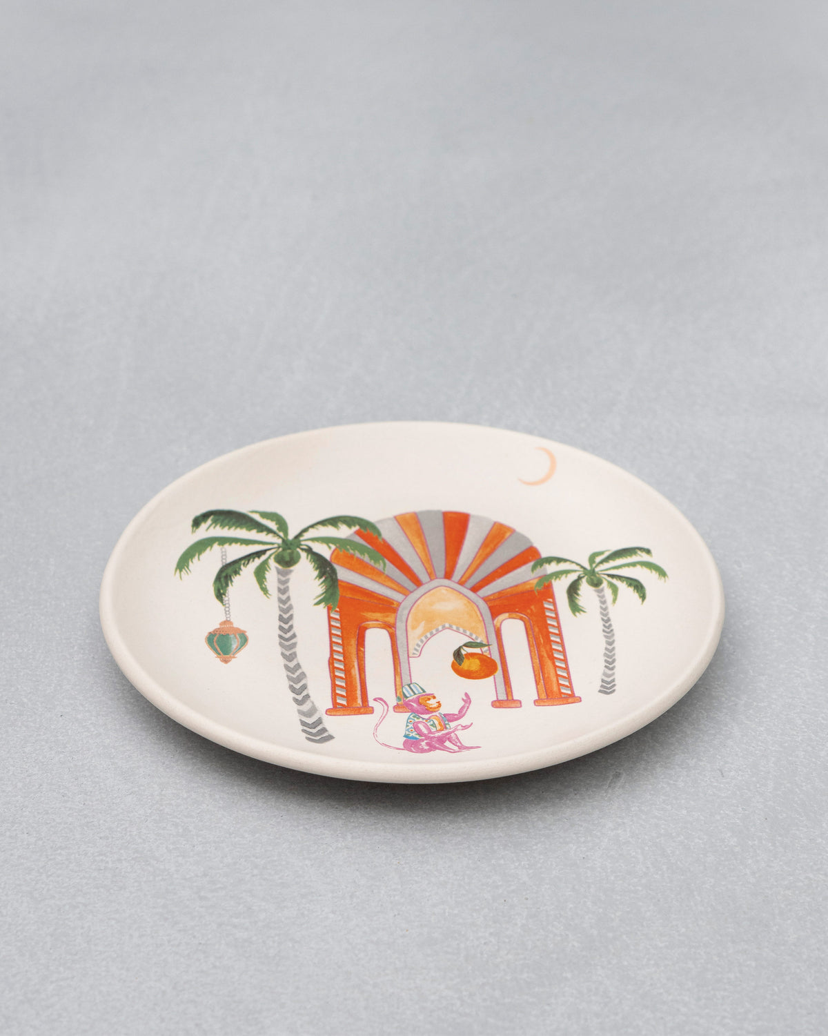 Angled view of the Mirage quarter plate showing its palm and arch motif.