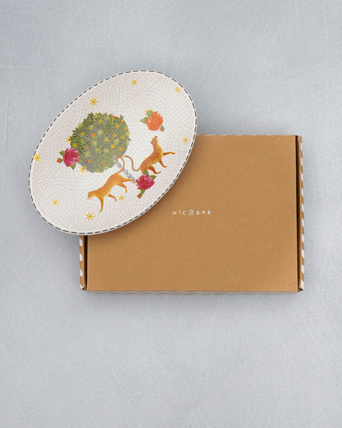 Mirage oval platter with leopard and rose motifs beside its box.