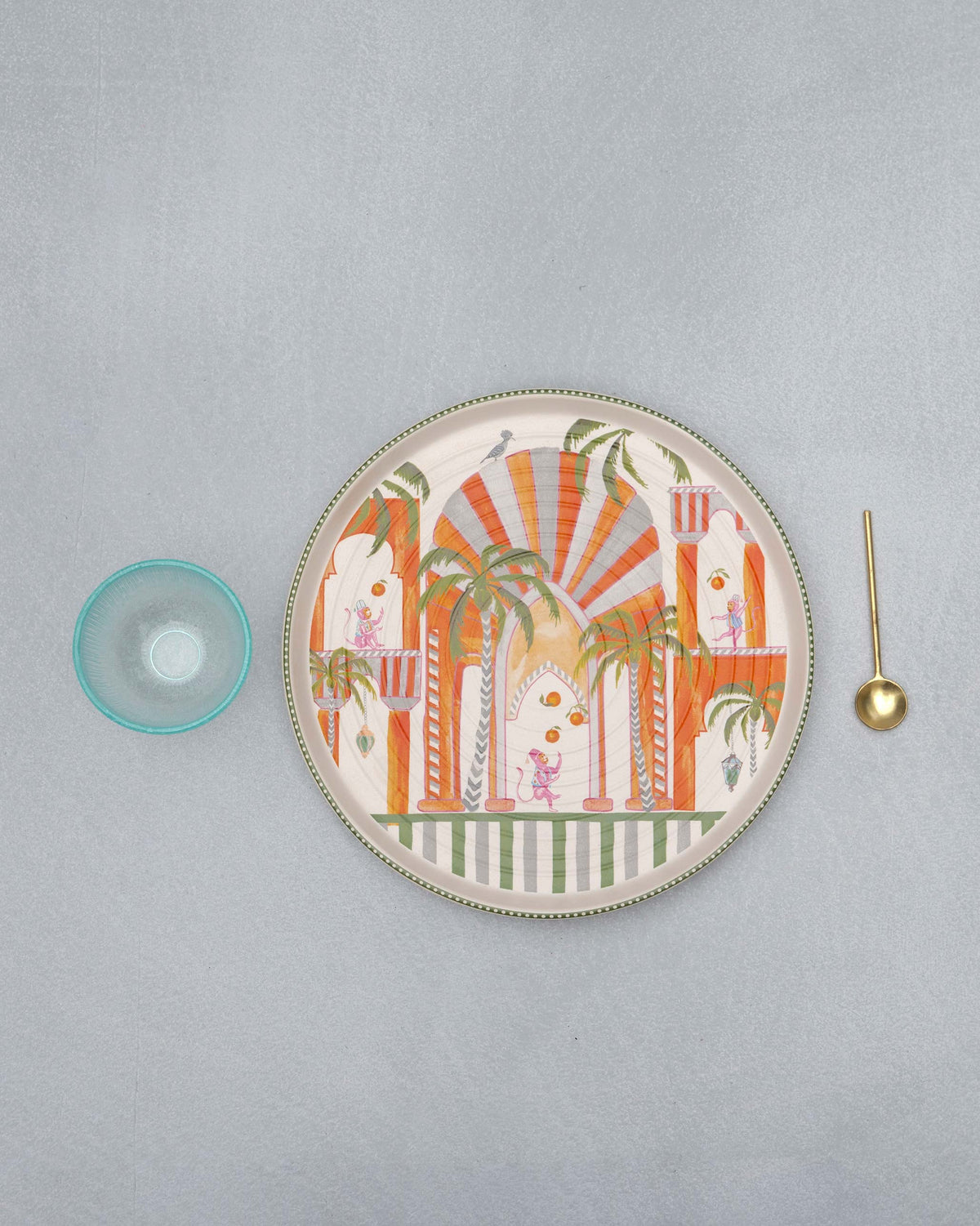 Mirage platter with palace and monkey print beside its dip bowl and spoon.