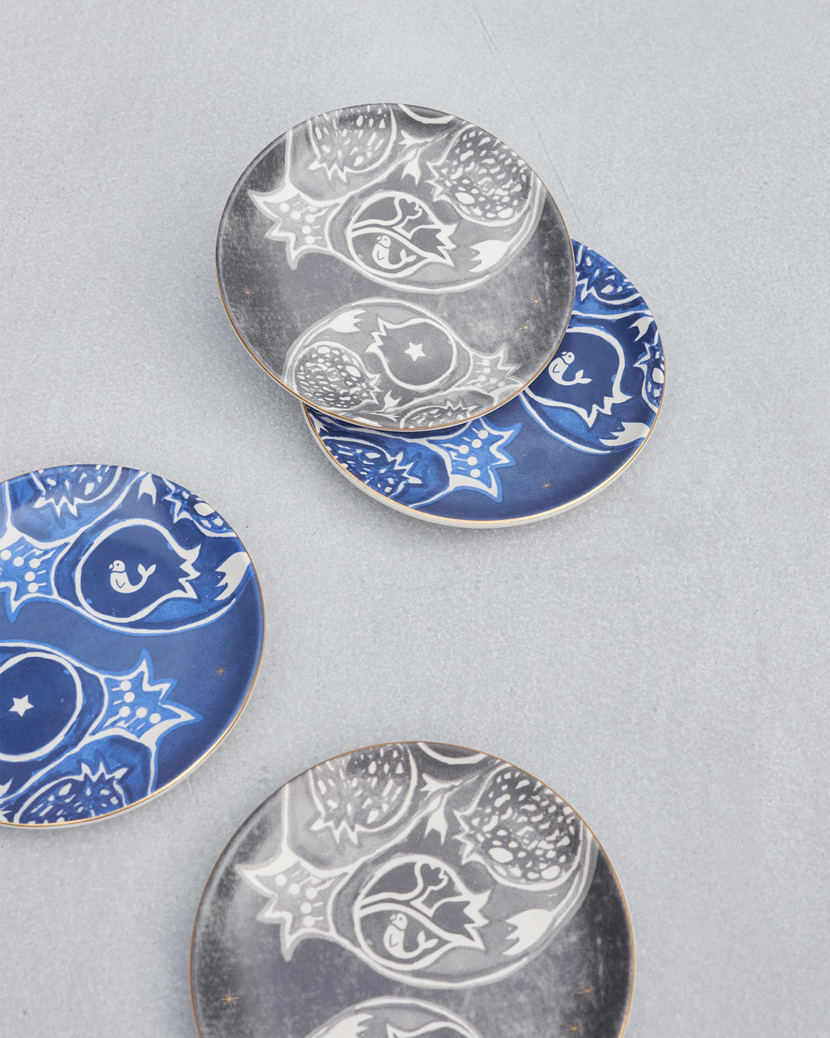 Four Desert Trail Tea Plates scattered with white pomegranate designs.
