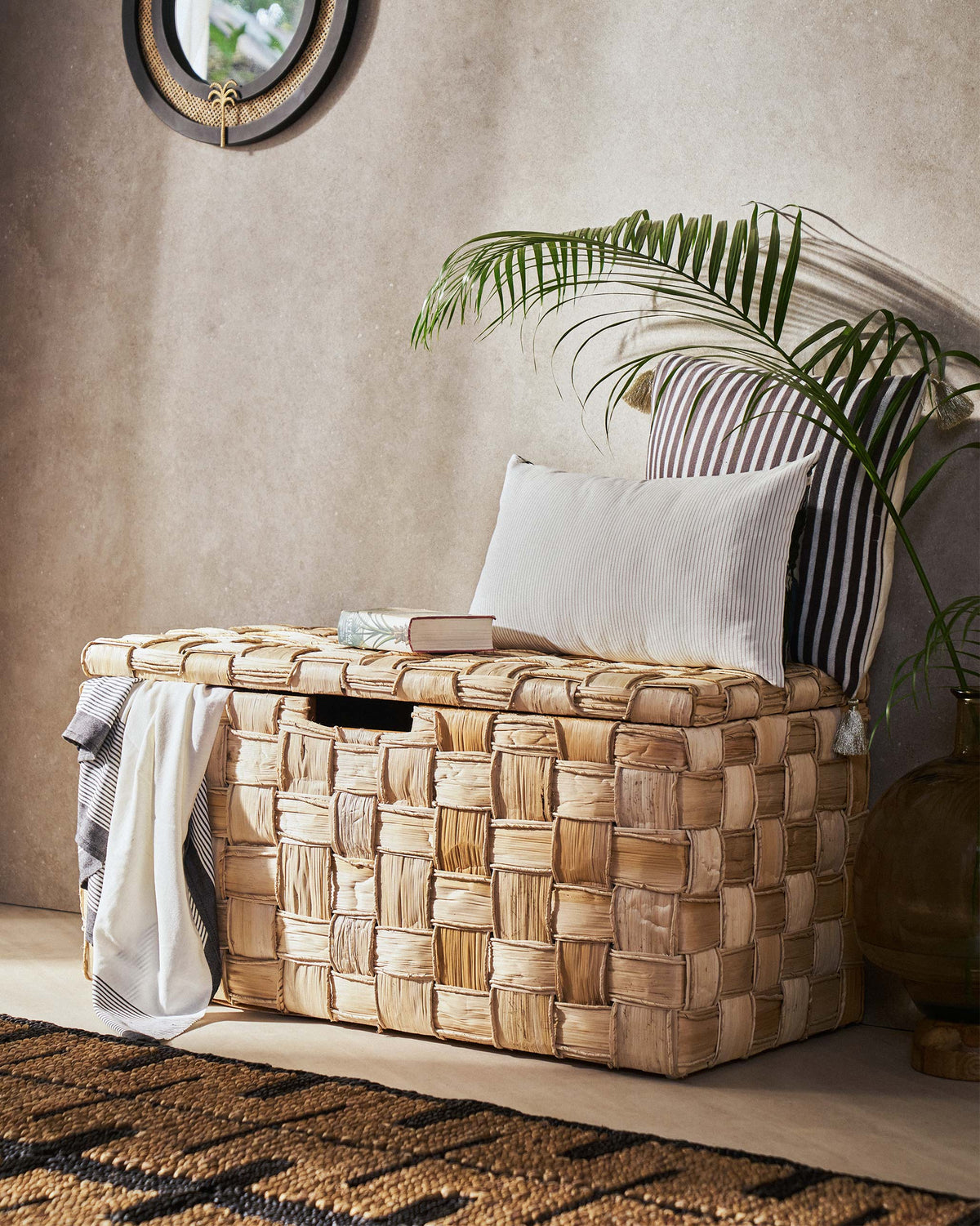 Mirage abaca trunk styled with striped cushions in a living space.